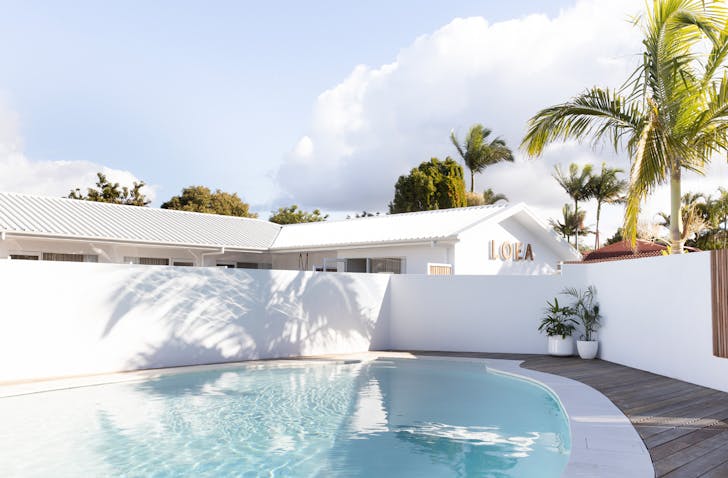 White exterior of LOEA Hotel on the Sunshine Coast, with their magnesium pool in the foreground.