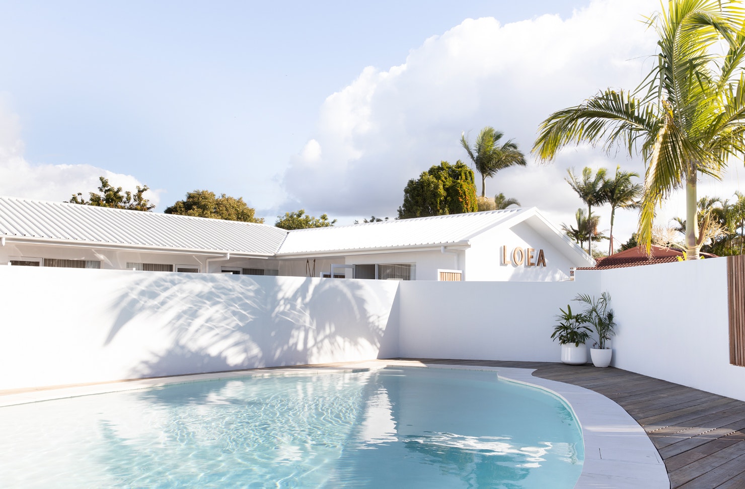 White exterior of LOEA Hotel on the Sunshine Coast, with their magnesium pool in the foreground.