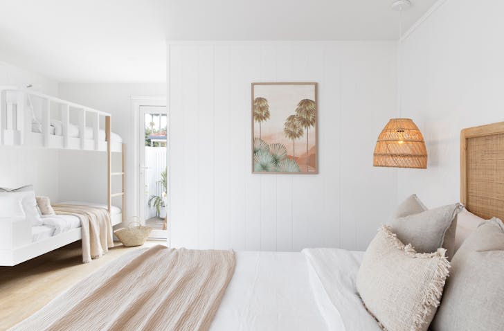The family room at LOEA Hotel, featuring custom-made bunk beds, a king size bed and lots of rattan features.