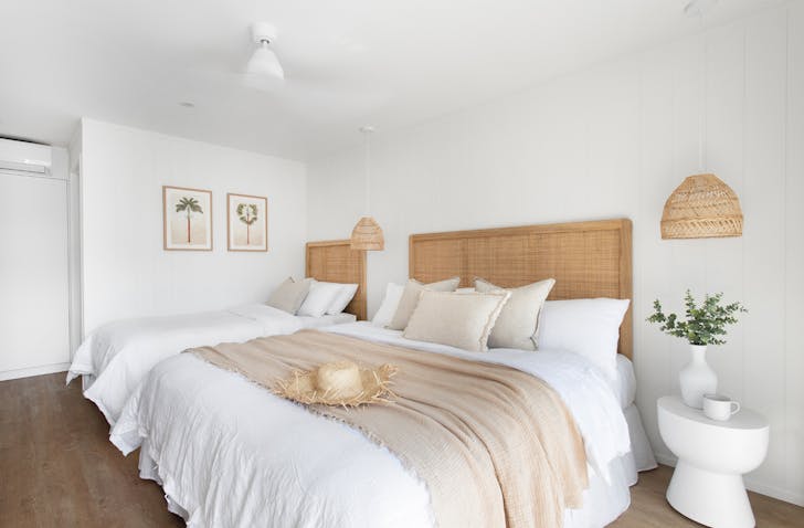 A room at LOEA Hotel, featuring lots of rattan details and a neutral-colours.