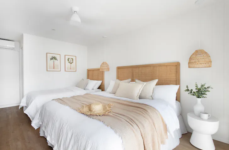 A room at LOEA Hotel, featuring lots of rattan details and a neutral-colours.