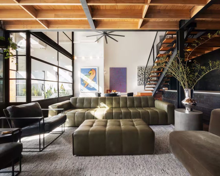 The interior of Loft 393, one of Melbourne's best Airbnbs, with sofa and huge windows