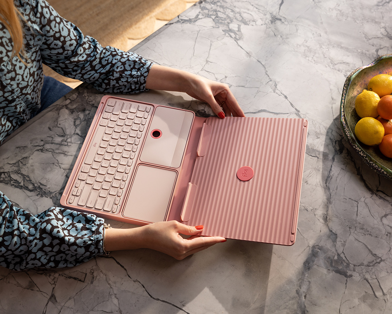 A pop-up laptop desk with keyboard and trackpad in blush by Logitech. 