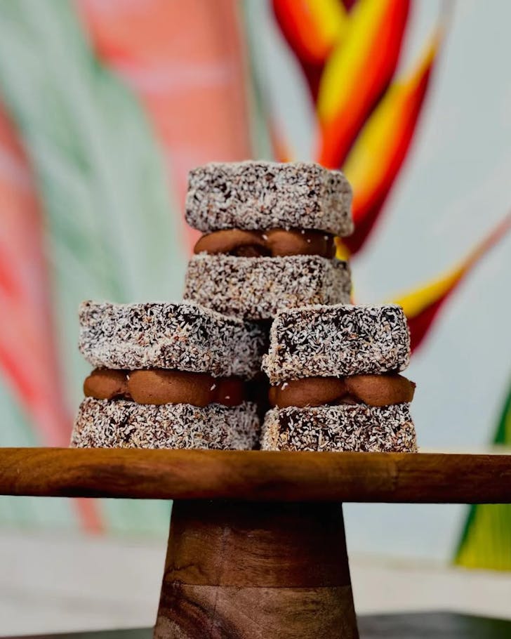 Chocolate lamingtons sit on a cakestand at Long Island Delicatessen. 