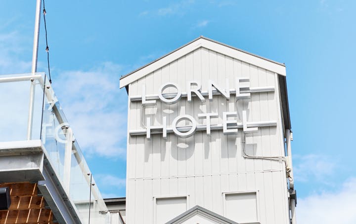 A large white building tower with blue skies in the background.