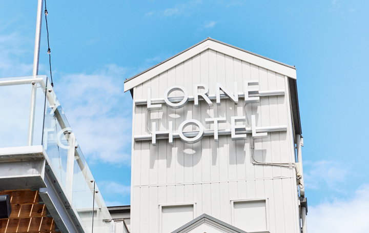 A large white building tower with blue skies in the background.