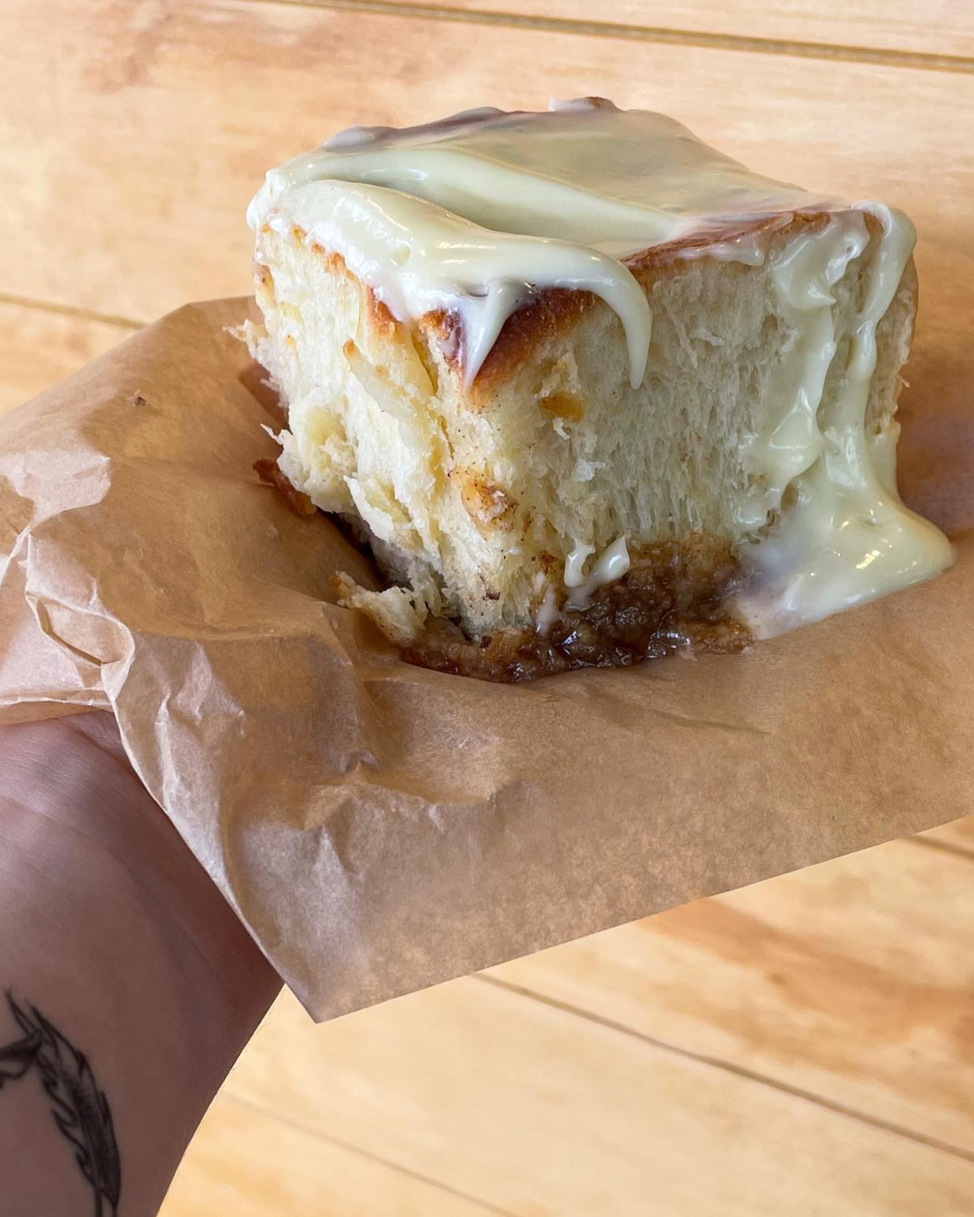 A fluffy cinnamon bun dripping with glossy frosting. 