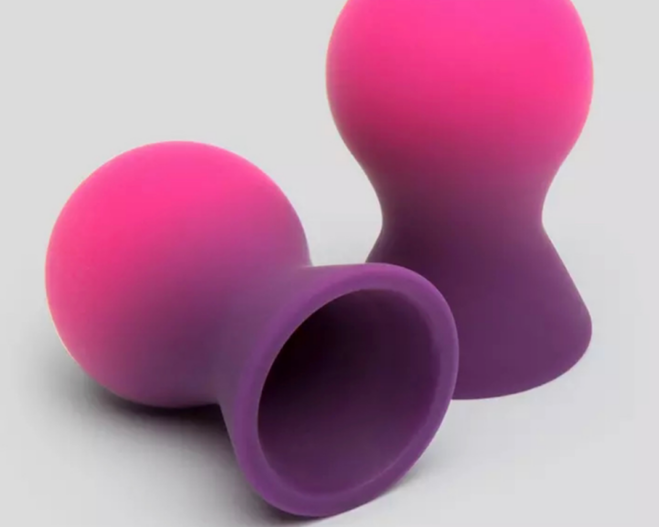 Semi-lightbulb-shaped two-tone silicone nipple suckers in pink and purple. 