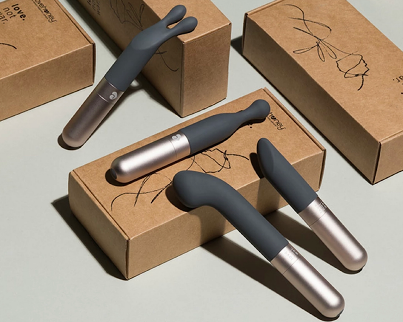 A bunch of different types of sleek silver vibrators scattered across brown box packaging. 