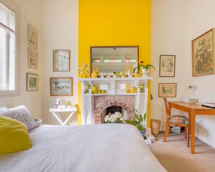 The bedroom with a yellow feature wall at Lovely Villa In Freemans Bay one of the best Auckland Airbnbs