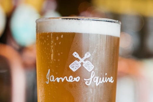 A pint glass of beer with the James Squire logo.