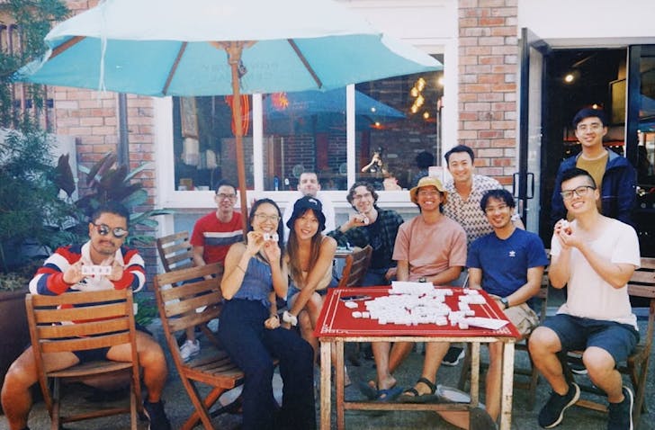 A group of people hang out and play mahjong. 