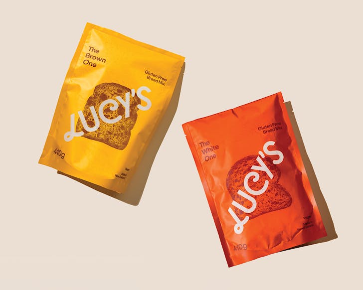 One yellow and one orange bag of Lucy's gluten-free bread mixes. 