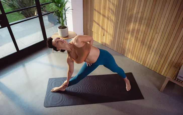 Woman doing yoga on a black mat