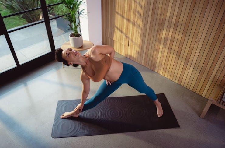 Woman doing yoga on a black mat