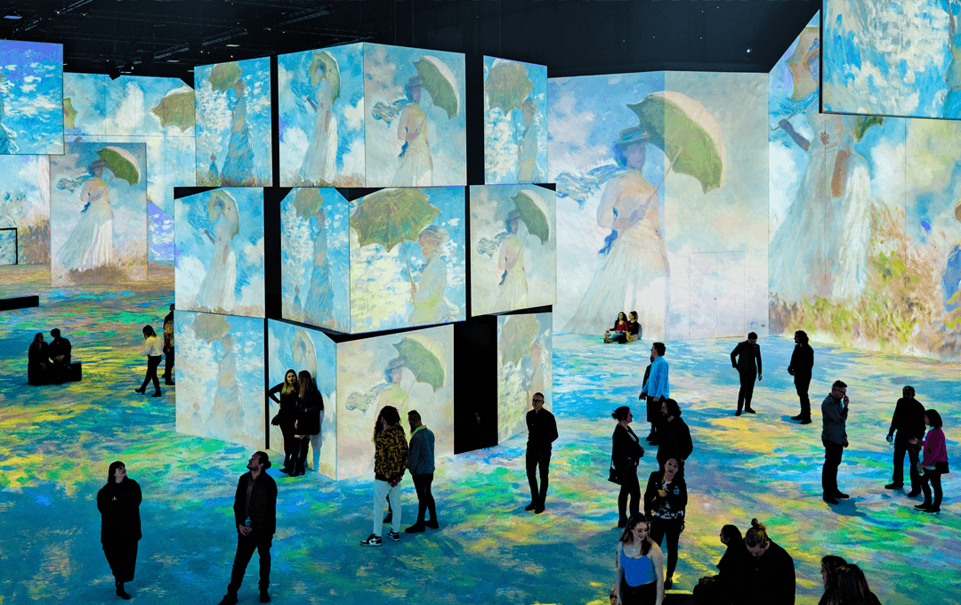 A large room filled with digital displays of artwork. 