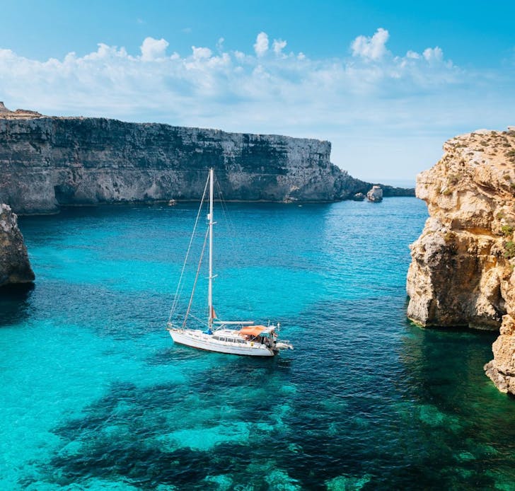 A boat in the water surrounded by amazing scenery