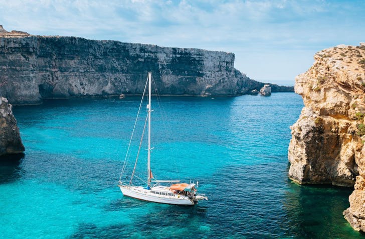 A boat floating on deep blue water in the sunshine