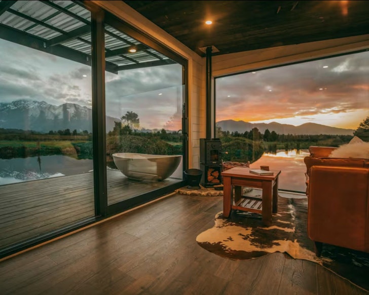 A view of mountains and water from Luxury Wilderness Cabin one of the best NZ Airbnbs