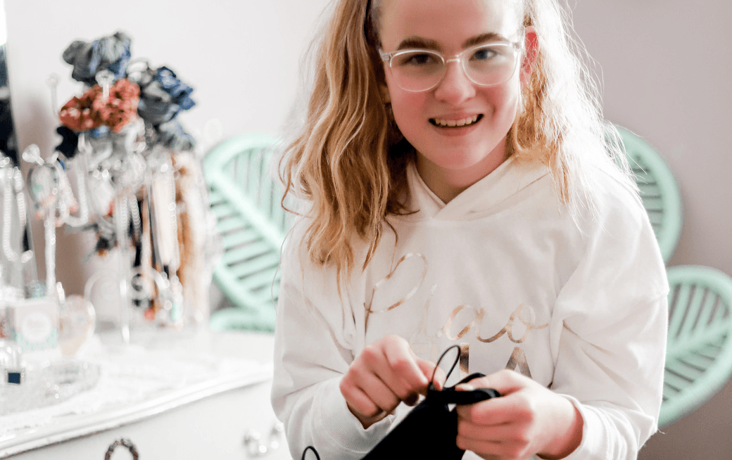 Emily smiling in a white jumper with the ModBodi underwear in her hands. 