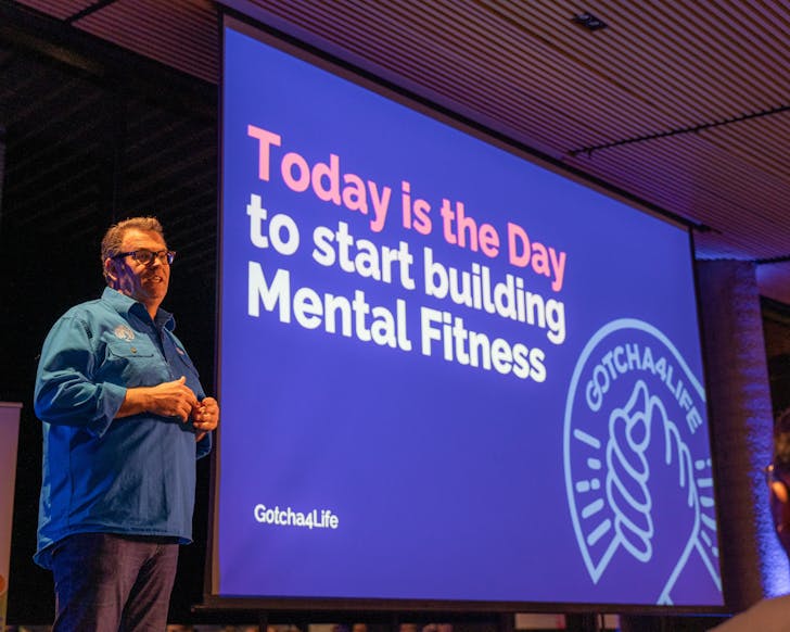 Gus Worland presents to a crowd on the mental fitness gym app