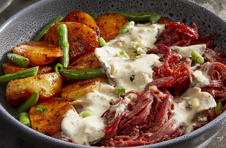 A steamy bowl of potato, greens and beef brisket.