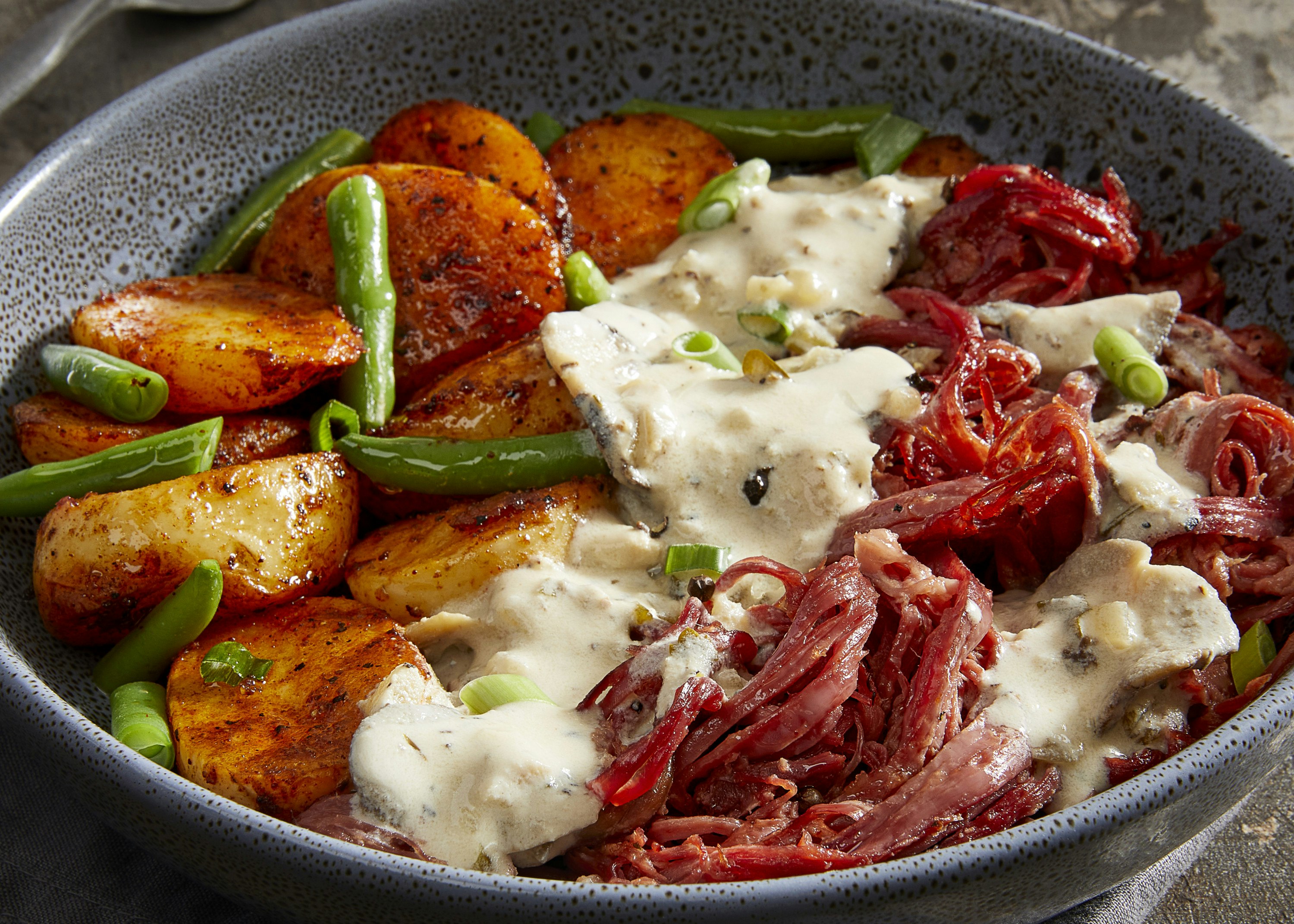 A steamy bowl of potato, greens and beef brisket.