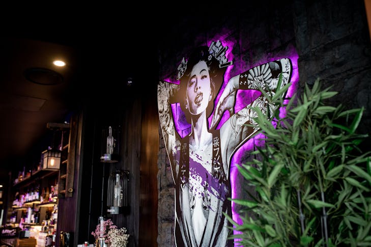 A neon-backed cutout of a geisha posing suggestively.