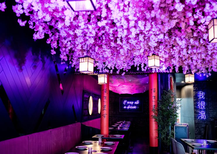 An interior shot of Maggie Choo's stunning neon pink interior, complete with hanging paper umbrellas.
