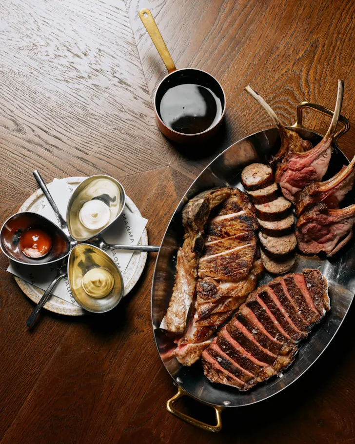 Steak and a slew of meat with sauces served up on a plate at MAGMA.
