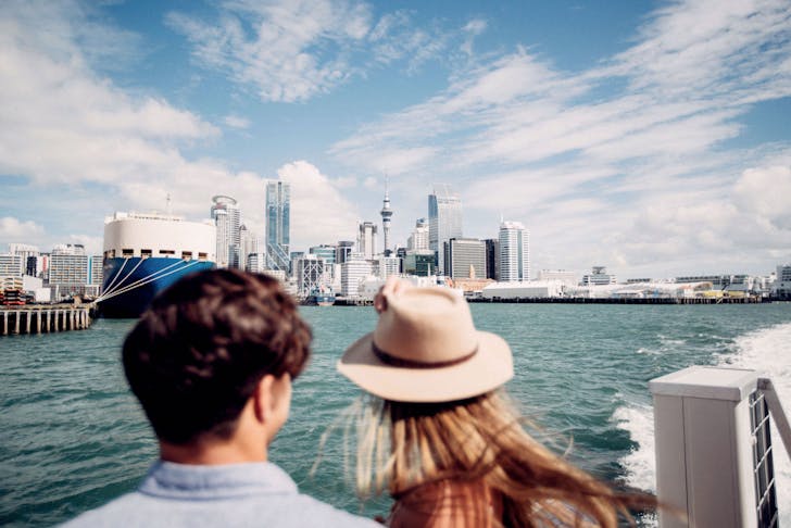 Man and woman admiring Auckland City while on a ferry to Waiheke