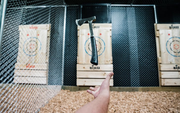Axe being thrown at wooden target board