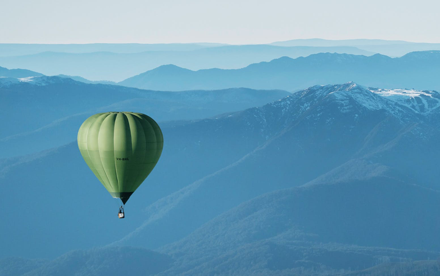 A large green hot air balloon overlooking the Victorian alpine region.