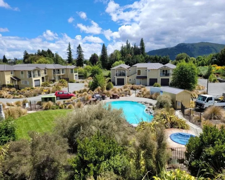 A view of the pool and hot tub with a backdrop of mountains at Mantra Lake Tekapo one of the best accommodation options in Lake Tekapo New Zealand