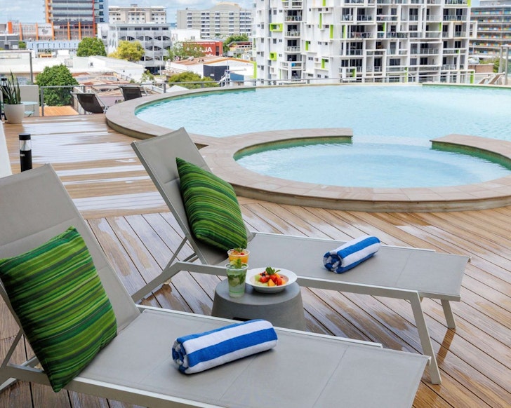 A view of two sun loungers by the pool at Mantra Pandanas one of the best Darwin hotels