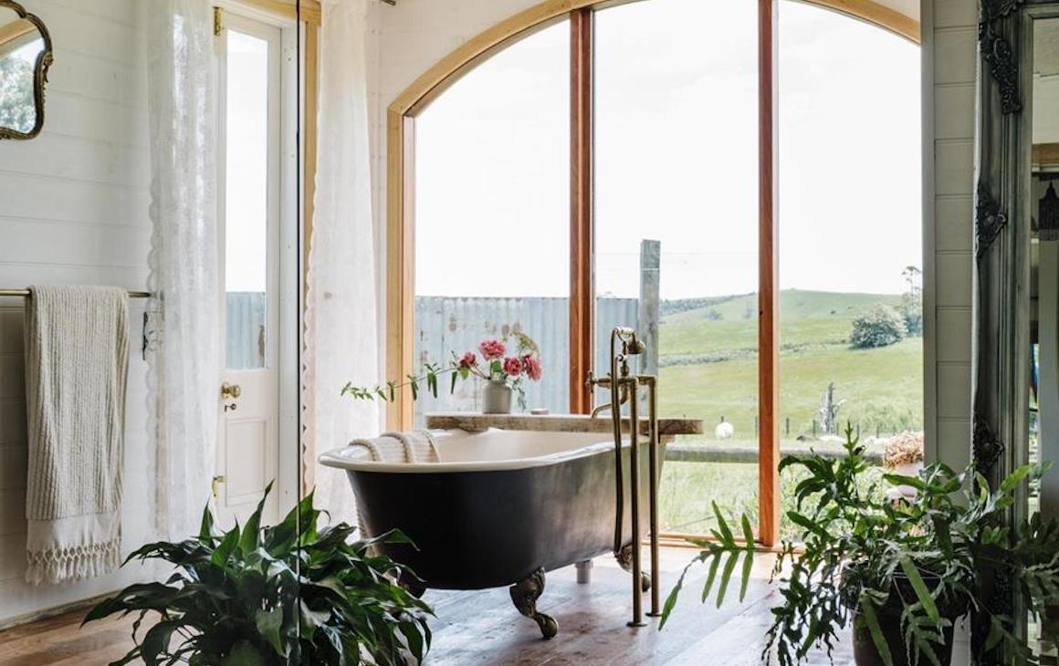 A freestanding bath overlooking a large window overlooking a field at one of the best romantic getaways.