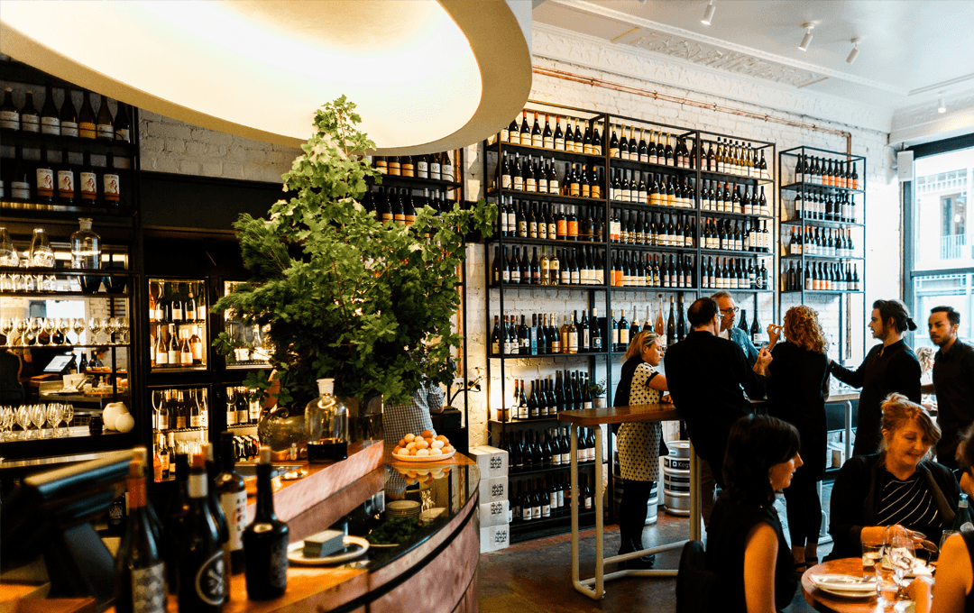 An interior shot of Marion, where wine lines the walls of one of the best restaurants Melbourne has to offer.
