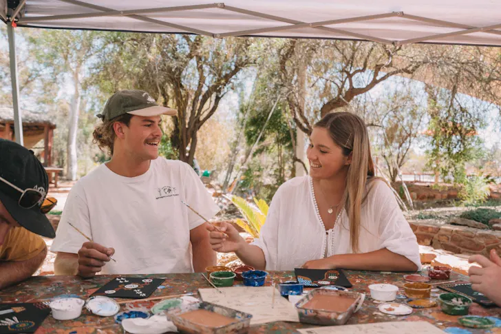 A couple take part in a painting workshop at Maruku Arts
