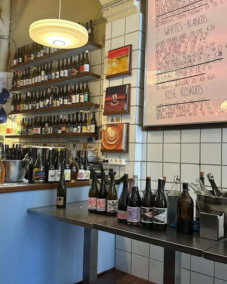 The laidback interiors, including a wall of wine bottles, at Masa Vins in Barcelona.
