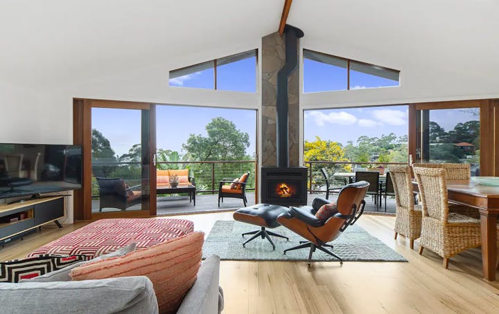 A large open-plan living room with a fireplace and blue skies. 