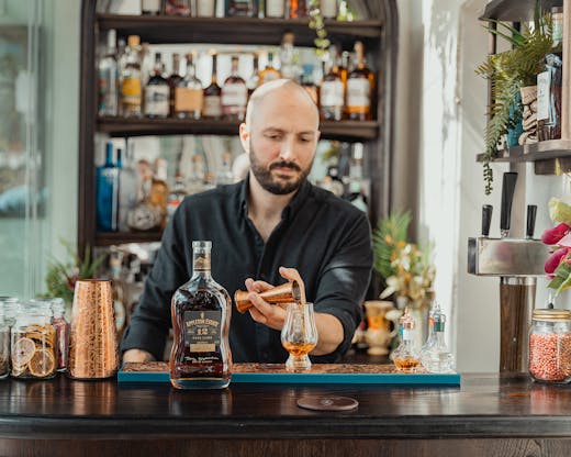 Adam mixed a cocktail at Mea's bar.