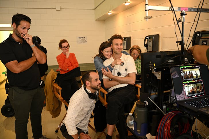 A group of people looking into a monitor.