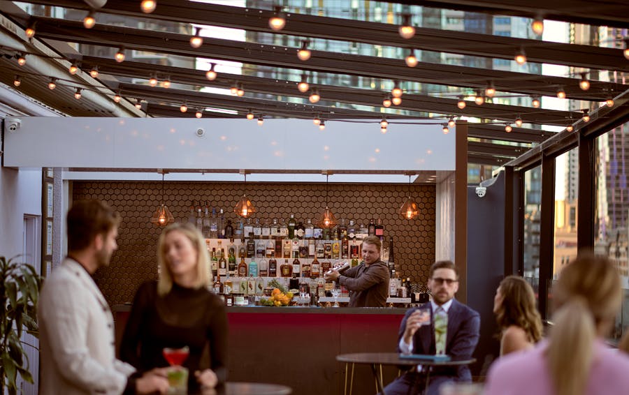 A bartender mixing a drink at a rooftop bar. 