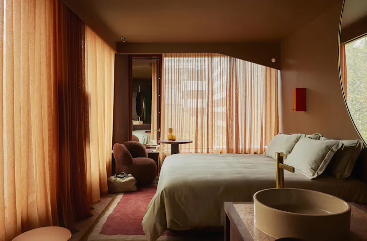 A bedroom in muted tones at Hyde Melbourne Place one of the best luxury Melbourne hotels
