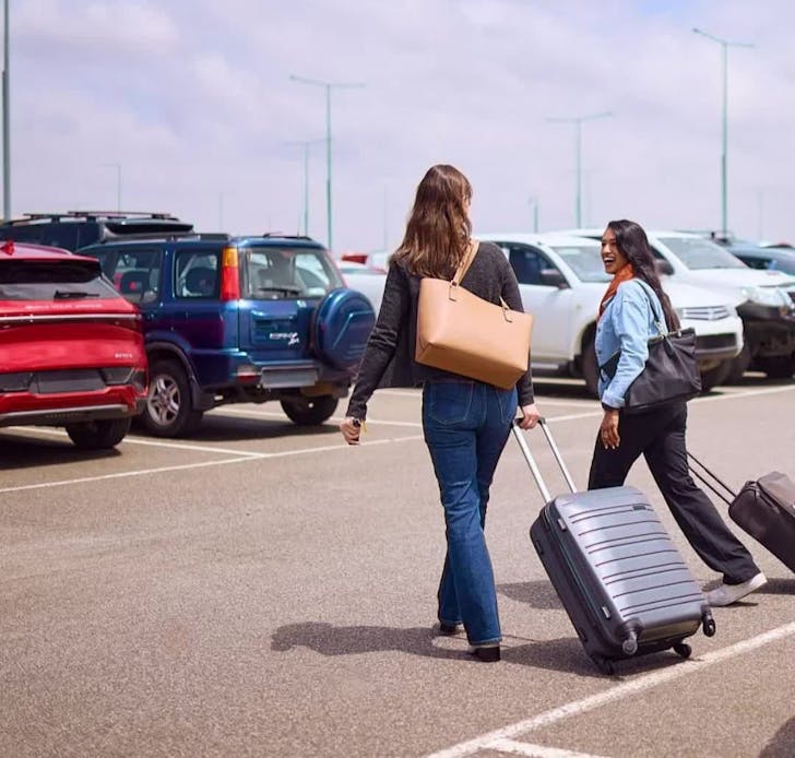 Two women with suitcases at Melbourne Airport Car Park