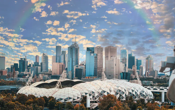 A view of the CBD with a rainbow in a blue sky. 