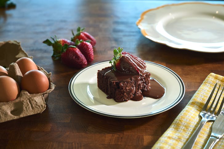 A decadent chocolate slab cake, drizzled with ganache and garnished with strawberries