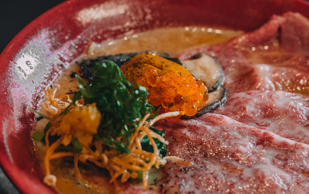 A red bowl full of some of the best ramen in Melbourne with wagyu beef. 