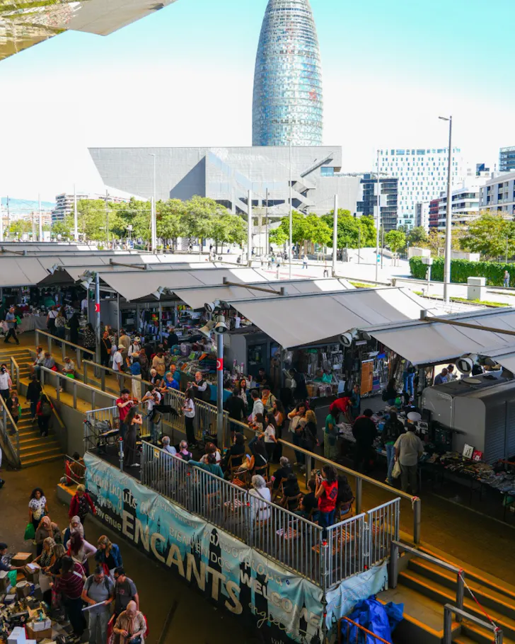 The mirrored roof of Mercat Dels Encants reflects the bustling market below.