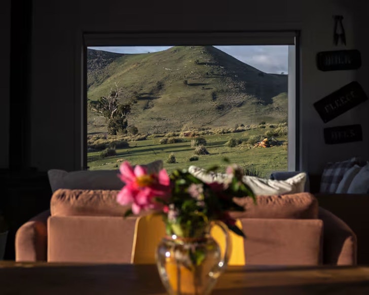 A view of a mountain through the window of Merino Cottage lake house Airbnb Tasmania